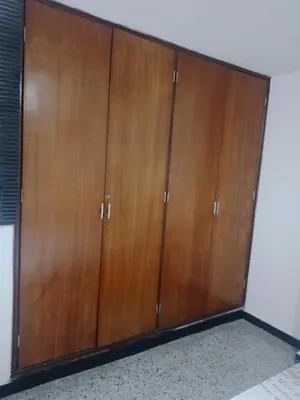 a pair of wooden cabinets in a room at Confortable habitación en apartamento familiar en el Prado in Barranquilla