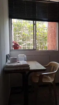 a table and two chairs in a room with a window at Confortable habitación en apartamento familiar en el Prado in Barranquilla