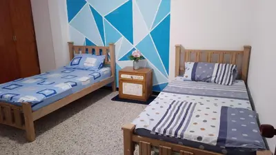 a bedroom with two beds and a wall with a mural at Confortable habitación en apartamento familiar en el Prado in Barranquilla