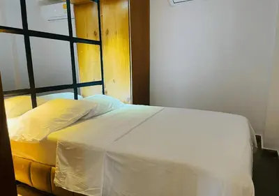 a white bed in a room with a window at Apartaestudios Calle 76 in Barranquilla