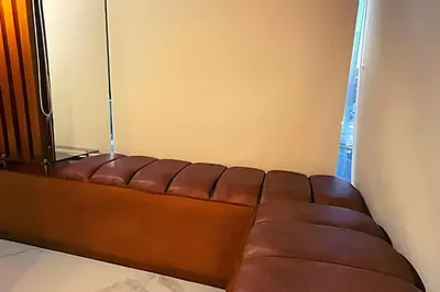 a brown leather couch sitting in a room at Apartaestudios Calle 76 in Barranquilla