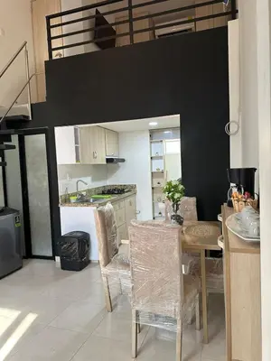 a kitchen with a table and chairs in a room at Apartaestudio Amoblado Tipo Loft en Barrio la Campiña in Cartagena de Indias