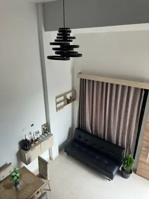 a living room with a black bench and a chandelier at Apartaestudio Amoblado Tipo Loft en Barrio la Campiña in Cartagena de Indias