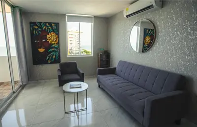 a living room with a blue couch and a chair at Stylish & Renovated Condo in El Laguito, Cartagena in Cartagena de Indias