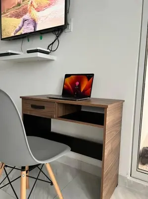 a desk with a laptop and a tv on a wall at Stylish & Renovated Condo in El Laguito, Cartagena in Cartagena de Indias