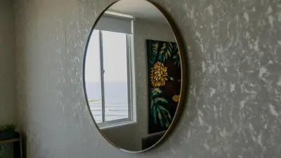 a mirror hanging on a wall with a window at Stylish & Renovated Condo in El Laguito, Cartagena in Cartagena de Indias