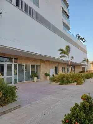a large building with a palm tree in front of it at New Apartment very close to Airport and beaches in Cartagena de Indias