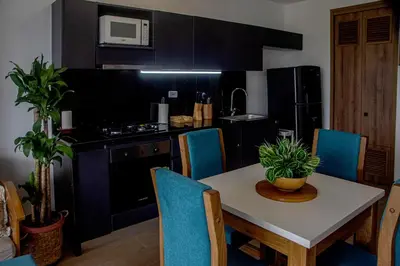 a kitchen with a table and chairs and a kitchen with black cabinets at Muranocentro1601 in Cartagena de Indias