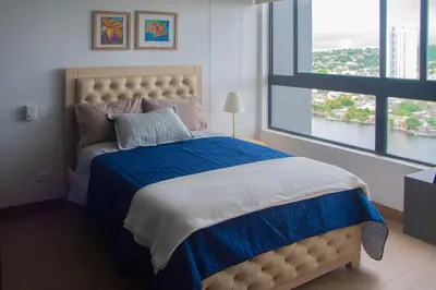 a bedroom with a large bed with a blue blanket at Muranocentro1601 in Cartagena de Indias