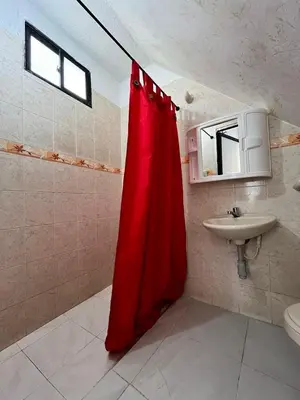 a bathroom with a red shower curtain and a sink at Hospedaje Las Palmas apto 203 in Cartagena de Indias