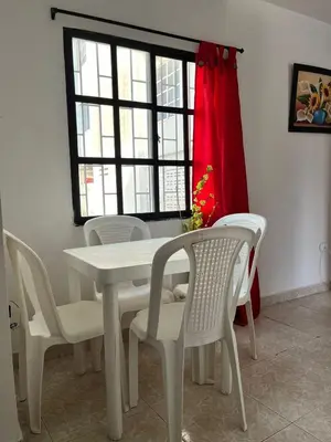 a white dining room table with white chairs and a window at Hospedaje Las Palmas apto 203 in Cartagena de Indias