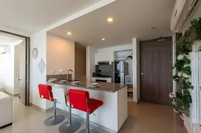 a kitchen with two red chairs at a counter at Awesome Oceanfront “Morros City” 29th floor 2R/3BR in Cartagena de Indias