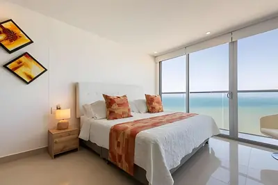 a bedroom with a bed with a view of the ocean at Awesome Oceanfront “Morros City” 29th floor 2R/3BR in Cartagena de Indias