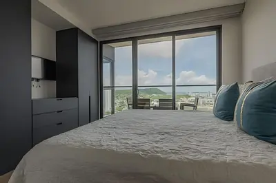 a bedroom with a large bed with a large window at Awesome View Historic Center, Castle and Sea 2BR in Cartagena de Indias