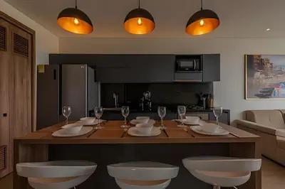 a kitchen with a table with chairs and wine glasses at Awesome View Historic Center, Castle and Sea 2BR in Cartagena de Indias