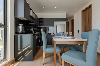 a kitchen with a wooden table and blue chairs at New Apt Beautiful Sea View and Walled City 2BR in Cartagena de Indias