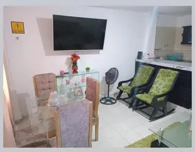 a living room with two chairs and a television on the wall at Casa rosymar in Cartagena de Indias