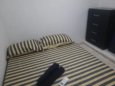a bed with two black pillows and a black cabinet at Casa rosymar in Cartagena de Indias