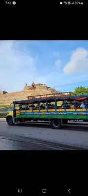 a bus driving down the road with people on it at Cartagena Beach Resort cerca al aereopuerto in Cartagena de Indias