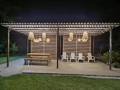 a wooden pergola with a wooden table and chairs at Hotel Aqua House in Tubará