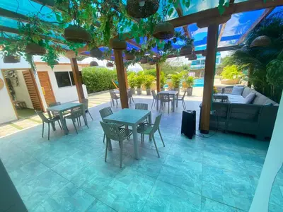 a patio with tables and chairs and a couch at Hotel Aqua House in Tubará