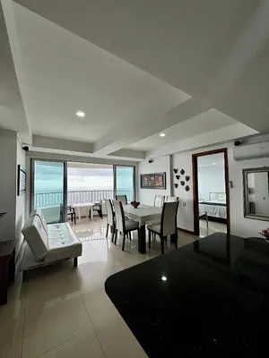 a living room with a table and chairs and the ocean at Paraíso en Bocagrande con Vista al Mar in Cartagena de Indias