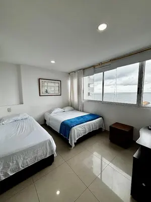 a bedroom with two beds and a large window at Paraíso en Bocagrande con Vista al Mar in Cartagena de Indias
