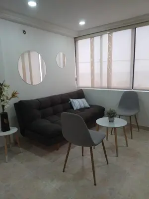 a living room with a black couch and two tables at Apto espectacular frente al mar in Cartagena de Indias