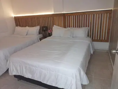 two beds in a hotel room with white sheets at Apto espectacular frente al mar in Cartagena de Indias