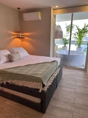 a bedroom with a bed and a tub in a room at DQ1301 | 2H Jacuzzi privado + piscina infinita in Cartagena de Indias