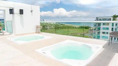 a hot tub on a patio with a view of the ocean at DQ1301 | 2H Jacuzzi privado + piscina infinita in Cartagena de Indias