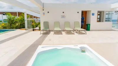 a swimming pool with chairs and a hot tub at DQ1301 | 2H Jacuzzi privado + piscina infinita in Cartagena de Indias