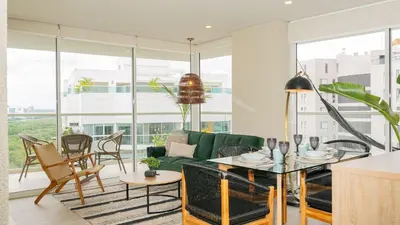 a living room with a green couch and a table at DQ1301 | 2H Jacuzzi privado + piscina infinita in Cartagena de Indias
