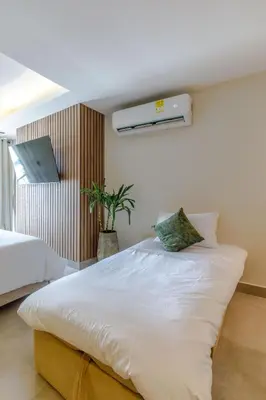 a bedroom with a large white bed with a tv on the wall at De la cruz Studio Apartments in Cartagena de Indias