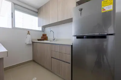 a kitchen with a stainless steel refrigerator and a sink at Bocagrande Loft - Livin Colombia in Cartagena de Indias