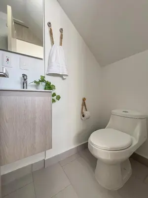 a white bathroom with a toilet and a sink at Bocagrande Loft - Livin Colombia in Cartagena de Indias