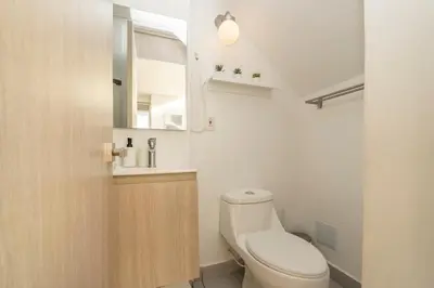 a small bathroom with a toilet and a sink at Luxury Duplex with Pool, Sunset Views, & Comfort in Cartagena de Indias
