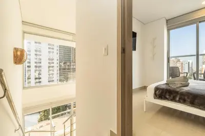 a bedroom with a bed and a large window at Luxury Duplex with Pool, Sunset Views, & Comfort in Cartagena de Indias