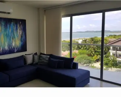 a living room with a blue couch and a large window at Apartamento Vista al Mar Morros Eco in Cartagena de Indias