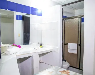 a white bathroom with a sink and a toilet at Hostal CORALES in Tolú