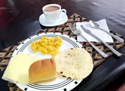 a plate of food with eggs and bread and a cup of coffee at Hostal CORALES in Tolú