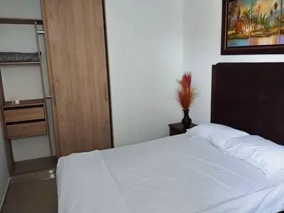 a bedroom with a white bed and a wooden door at Apartamento en Cartagena, Zona Urbana in Cartagena de Indias
