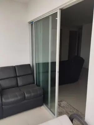 a black couch in a living room with a glass door at Apartamento en Cartagena, Zona Urbana in Cartagena de Indias