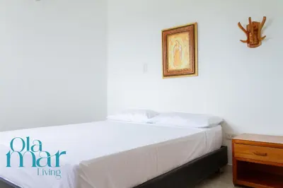 a bedroom with a white bed with a picture on the wall at Atardeceres bloque A in Coveñas