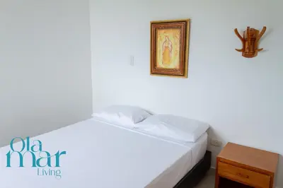 a bedroom with a white bed with a picture on the wall at Atardeceres bloque A in Coveñas
