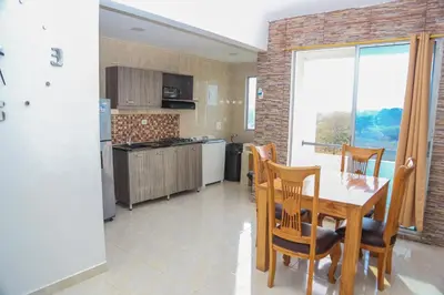 a kitchen with a table and chairs and a window at Atardeceres bloque A in Coveñas