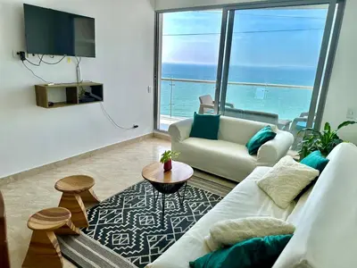 a living room with a white couch and a large window at by Calamari Homes - Altamar 30B1 near walled city in Cartagena de Indias