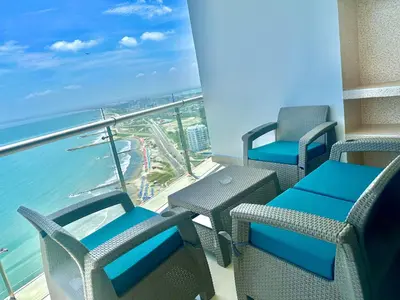 a balcony with chairs and tables and the ocean at by Calamari Homes - Altamar 30B1 near walled city in Cartagena de Indias