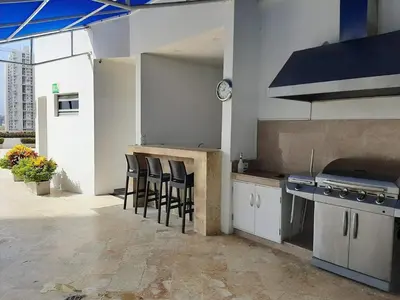 a kitchen with a counter with stools and a stove at by Calamari Homes - Altamar 30B1 near walled city in Cartagena de Indias