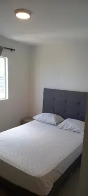 a bed with a blue headboard and two pillows at Apartamento - Edf Acuarium - Torices in Cartagena de Indias
